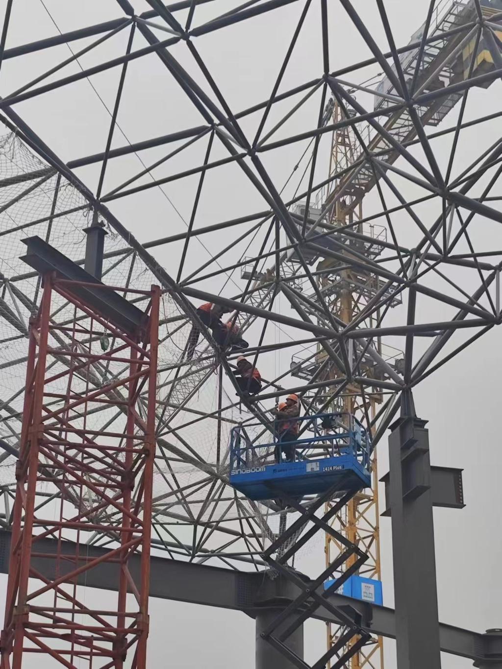 滨水会展中心工人正在进行钢结构架网安装工作